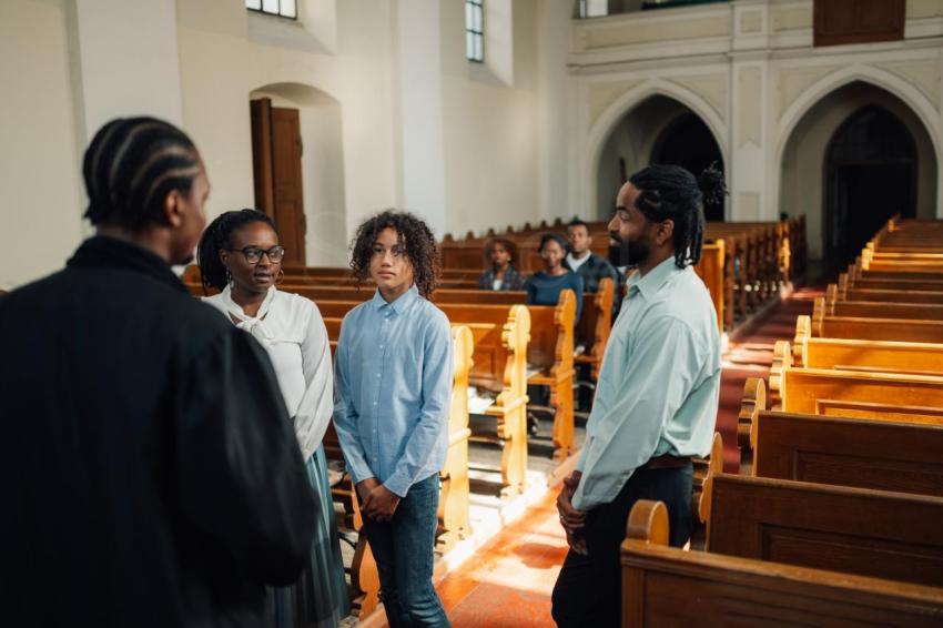 African american family standing and listening to priest in church