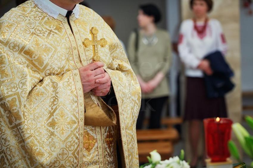 Beautiful golden cross in male hands of priest