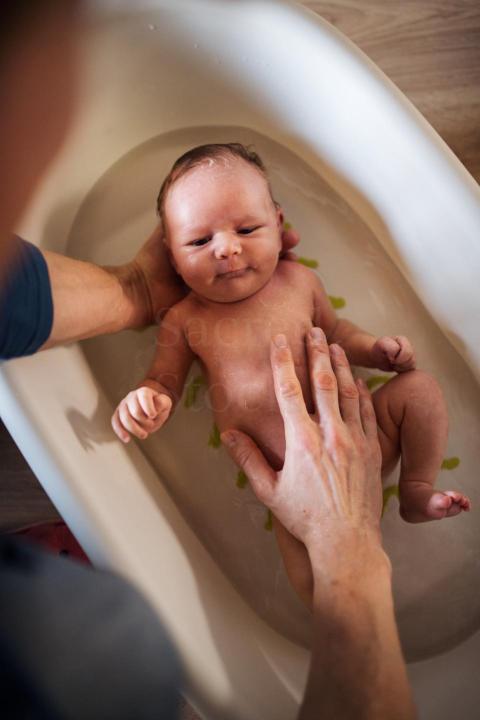top view of unrecognizable parent giving a newborn